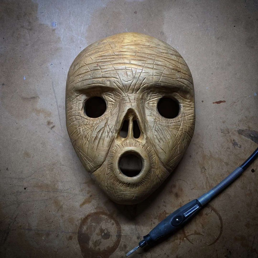 Hand-carved ghost and skull-inspired wooden mask by Jared Carves